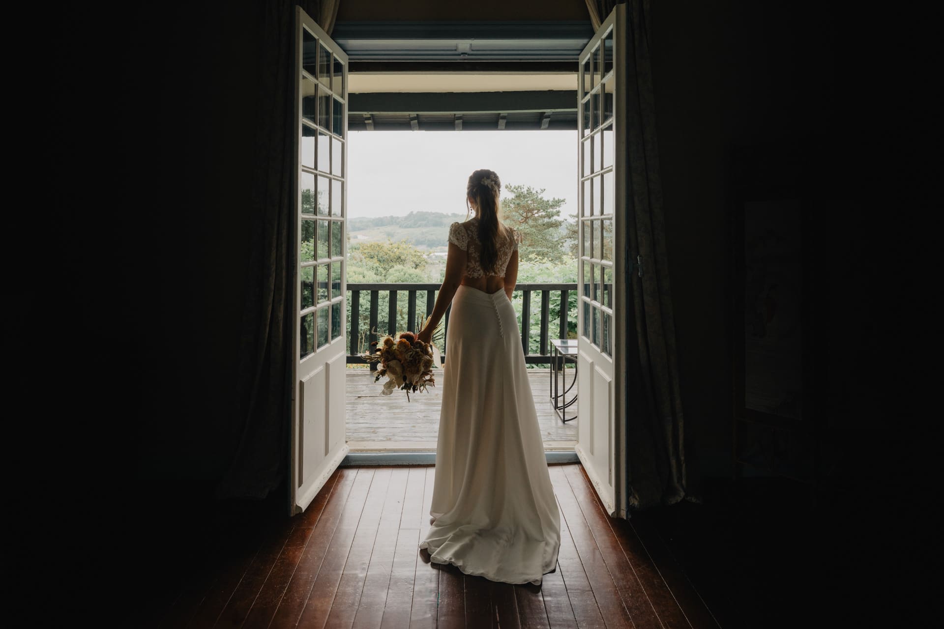 Préparatifs de la mariée. Portrait en contre jour dans la suite nuptiale du domaine de larbéou. Par le photographe Julien Marchione