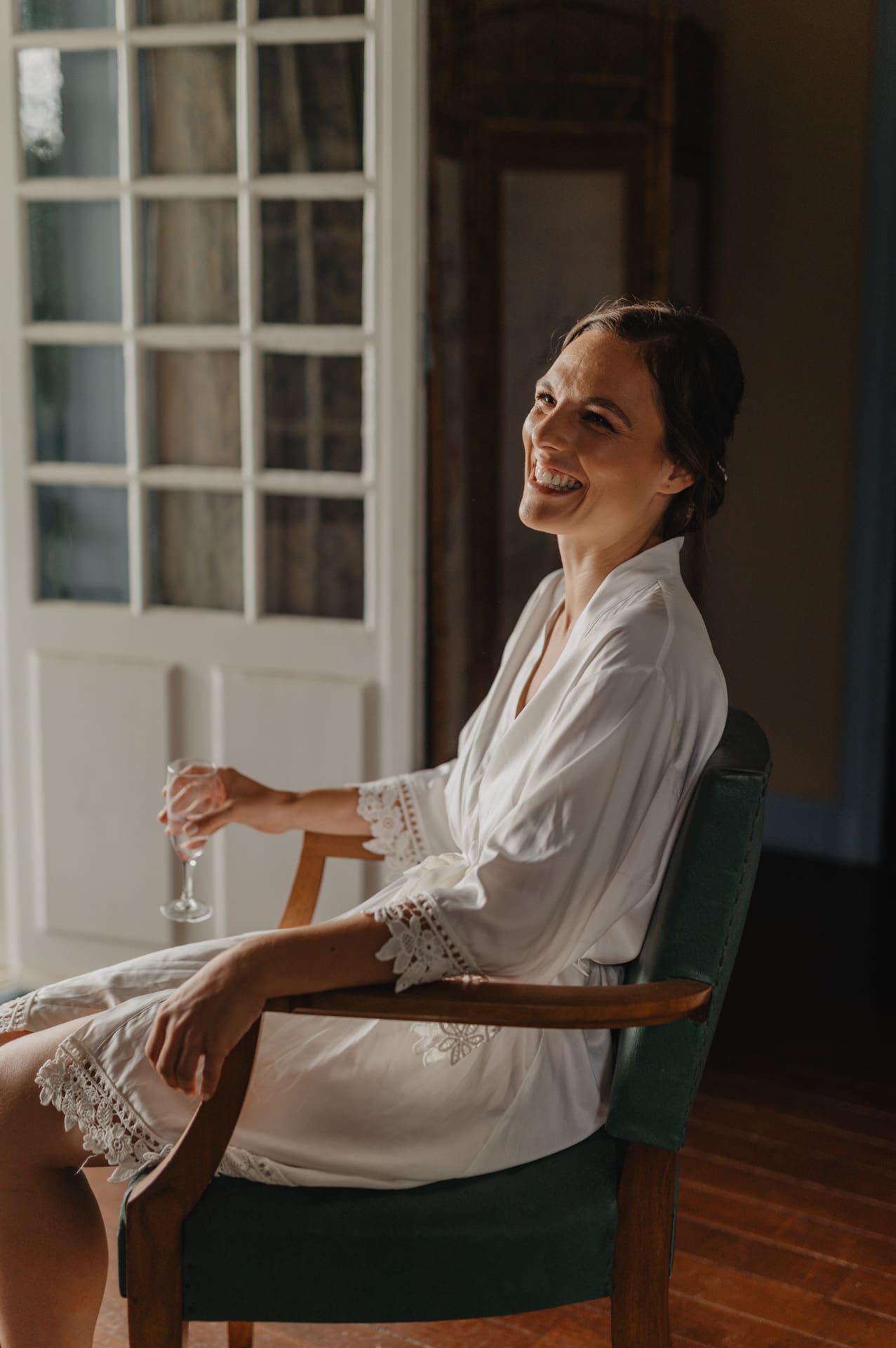 Une mariée boit une coupe de champagne pendant les préparatifs de mariage au Domaine de Larbéou. Par le photographe Julien Marchione