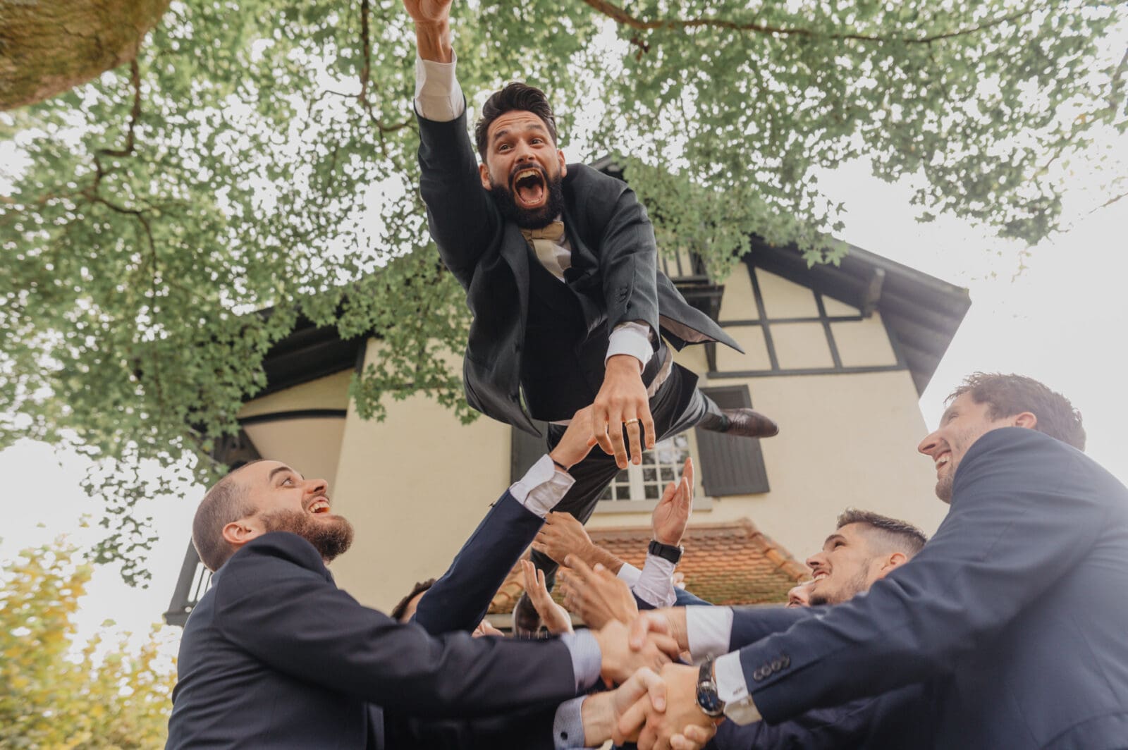 Les garçon d'honneur font sauter le marié dans le ciel en mode superman au Domaine de Larbéou à Bayonne. Par le photographe Julien Marchione