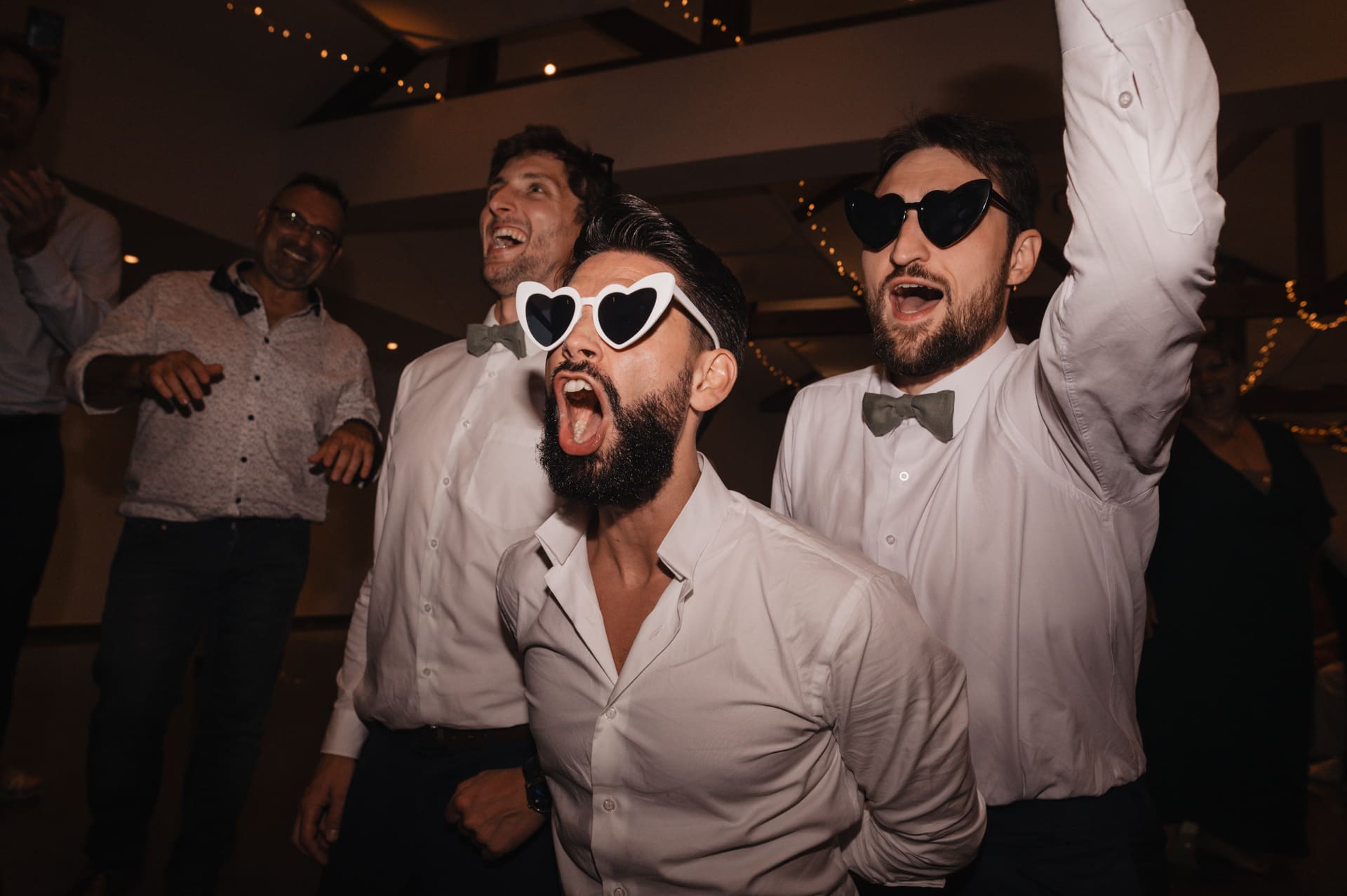Le marié et les garçons d'honneur avec des lunettes sur le dancefloor d'un mariage au Domaine de Larbéou à Bayonne. Par le photographe Julien Marchione